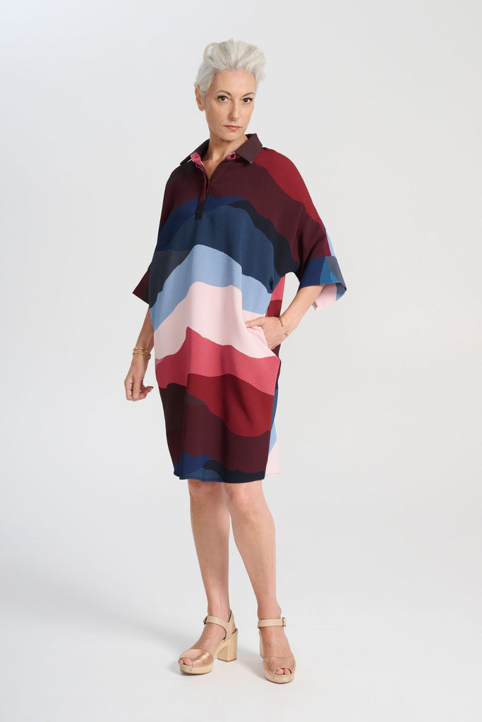 Olga de Polga Kona Skylone Estilo Shift dress in heavy crepe. With a shirt collar and buttons at the neck. Half sleeves with a batwing shape. Knee length. side front view on model