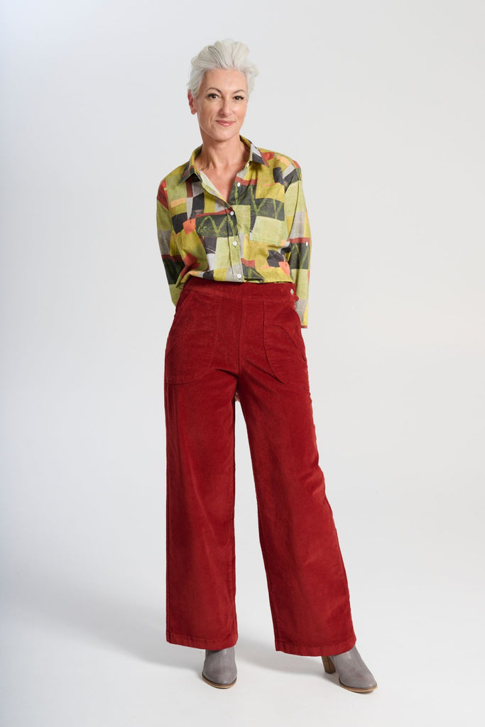 Olga de Polga Red Peggy Sue Long Pants in Vino. Made in soft cotton velvet corduroy. Back elastic waist, front flat waistband. Large patch pockets. Front view on model.