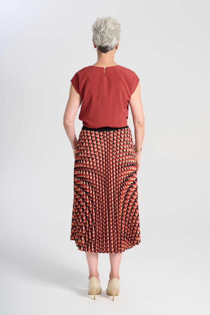 Olga de Polga printed pleat skirt in the Seraph Sunset print. Shades of orange, red and black. Fully elasticated waistband.  Back view on model