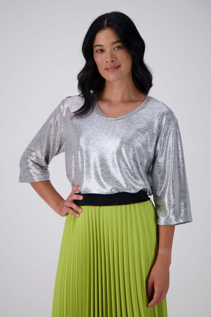 Olga de Polga silver prosecco top. Crafted from a soft, woven metallic fabrication, this top is comfortable enough to wear all day and night. With a relaxed fit, scoop neckline, and 3/4 length sleeves, your everyday t-shirt now boasts a lustrous twist.  Front tucked in view