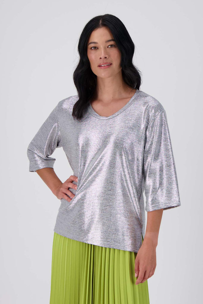 Olga de Polga silver prosecco top. Crafted from a soft, woven metallic fabrication, this top is comfortable enough to wear all day and night. With a relaxed fit, scoop neckline, and 3/4 length sleeves, your everyday t-shirt now boasts a lustrous twist.  Front close up view