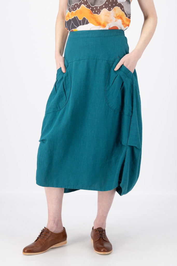 Olga de Polga Milwaukee Fiesta Teal skirt in 100% slub linen.  Our Milwaukee Fiesta skirt is an incredibly unique, chic and original skirt. It is universally flattering, highly versatile, and super comfortable. Perfect to throw on and go. Front  close-up view on model.