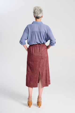 Olga de Polga Hepburn Haven skirt in Vino wool/linen. Unique front button feature, and has a back split. Finishes below the knee. Back elasticated waistband. Back view on model.
