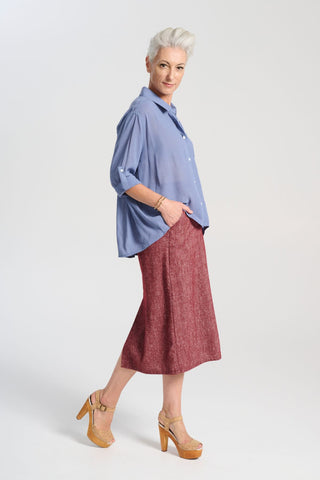 Olga de Polga Hepburn Haven skirt in Vino wool/linen. Unique front button feature, and has a back split. Finishes below the knee. Side view on model