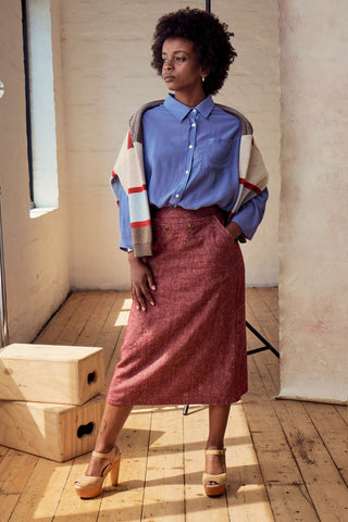 Olga de Polga Hepburn Haven skirt in Vino wool/linen. Unique front button feature, and has a back split. Finishes below the knee.  Front full view on model with hand in pocket.
