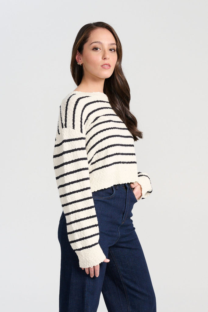Olga de Polga White Captains Knit Sweater with thin nautical stripes. Round neckline. Long sleeves and a cropped body which drapes longer at the sides. Side view on model
