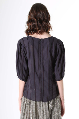 Olga de Polga Avenida Blouse Ink Blue Navy. Our signature Olga Blouse is a feminine staple that can take you from work to weekend with ease. With a slim cut that narrows slightly at the waist, the blouse features a beautifully detailed lantern sleeve with a drop shoulder and delicate pleating on the shoulder and cuff. It also has a wide boat neckline and invisible zip fastening at the back.