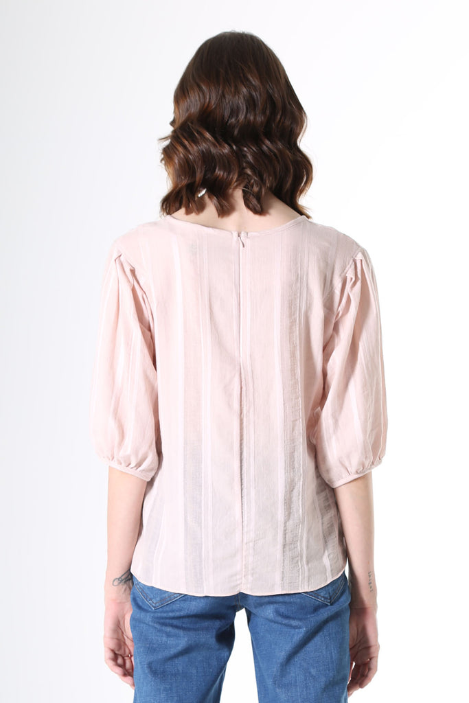 Olga de Polga Blouse in Avenida textured cotton pale pink. the blouse features a beautifully detailed lantern sleeve with a drop shoulder and delicate pleating on the shoulder and cuff. It also has a wide boat neckline and invisible zip fastening at the back.
