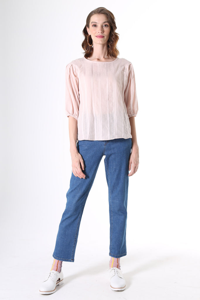 Olga de Polga Blouse in Avenida textured cotton pale pink. the blouse features a beautifully detailed lantern sleeve with a drop shoulder and delicate pleating on the shoulder and cuff. It also has a wide boat neckline and invisible zip fastening at the back.