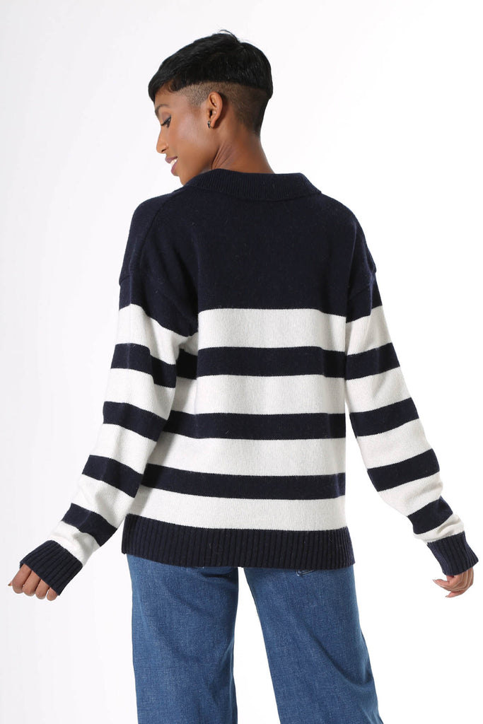 Olga de Polga Coota Long Striped Sweater. Blending the relaxed fit of a polo sweater with the luxury of cashmere, this is the perfect weekend knit. Long length that falls below the hip, relaxed fit, with an open collar, v-neck and dropped shoulder. Patterned with wide and narrow horizontal navy stripes.