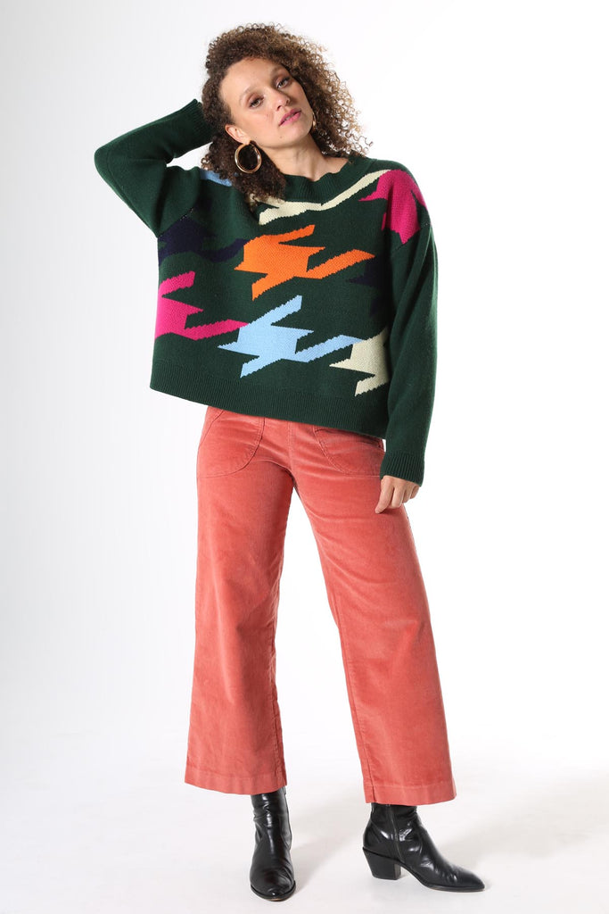 woman in green patterned knit sweater and salmon pants