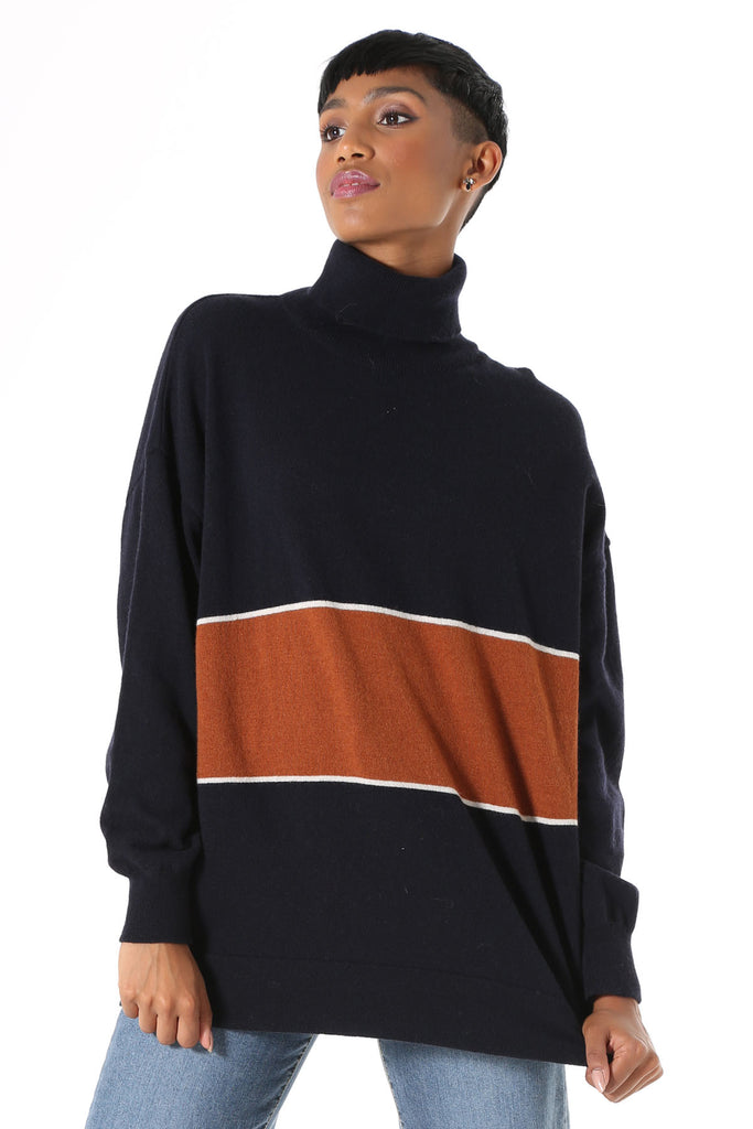 Olga de Polga Mariana Turtleneck sweater Navy. Oversized long length boyfriend style knit, with rolled turtleneck and dropped shoulder. Fine light-weight wool viscose. Featuring a wide stripe with a fine white border.