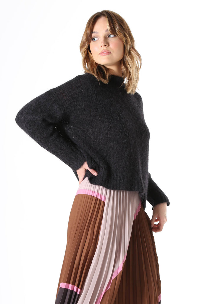 Olga de Polga Copenhagen knit sweater in black with long sleeves and a crew neckline. Side view, worn by model