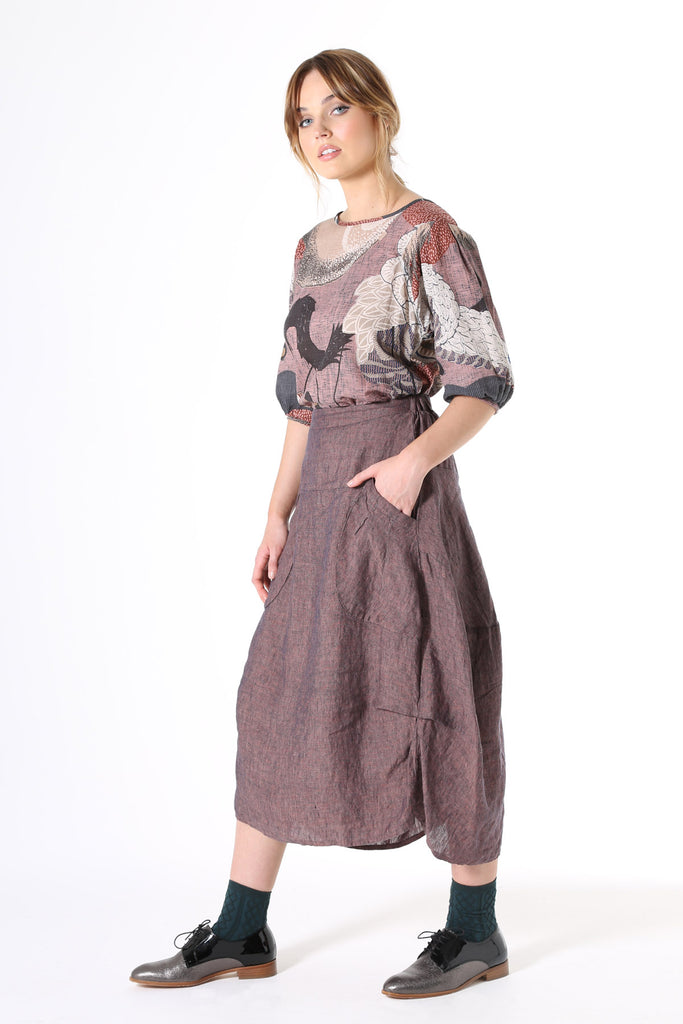 Olga de Polga Milwaukee skirt in Mauve purple.  It has a unique, slightly structured A-line panelled design with gathered details at the hem and oversized pockets. The waistline has a flat front and elastic waistband at the back, making it perfect to throw on and go.  Light-weight, soft, textured linen with an irredescent quality. Has a flowy drape that falls elegantly.