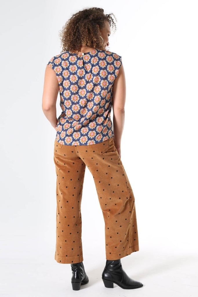 Olga de Polga printed tee Olga-de-lis.  Our signature Olga Tee is a slim cut, fitted at the shoulders and waist, with cap sleeves and a round neck, and a button fastening at the back. Fun vintage inspired block print in navy, with motifs in beige, mustard and hot pink. Made in our signature light-weight cotton/rayon fabric with a soft floaty drape. 
