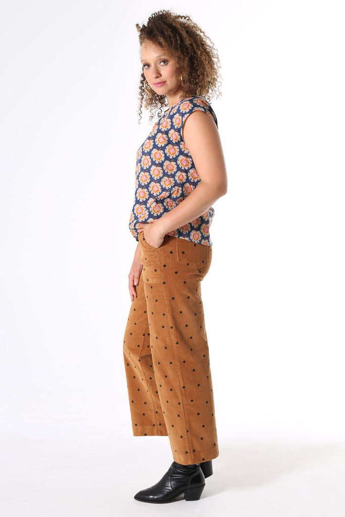 Olga de Polga printed tee Olga-de-lis.  Our signature Olga Tee is a slim cut, fitted at the shoulders and waist, with cap sleeves and a round neck, and a button fastening at the back. Fun vintage inspired block print in navy, with motifs in beige, mustard and hot pink. Made in our signature light-weight cotton/rayon fabric with a soft floaty drape. 