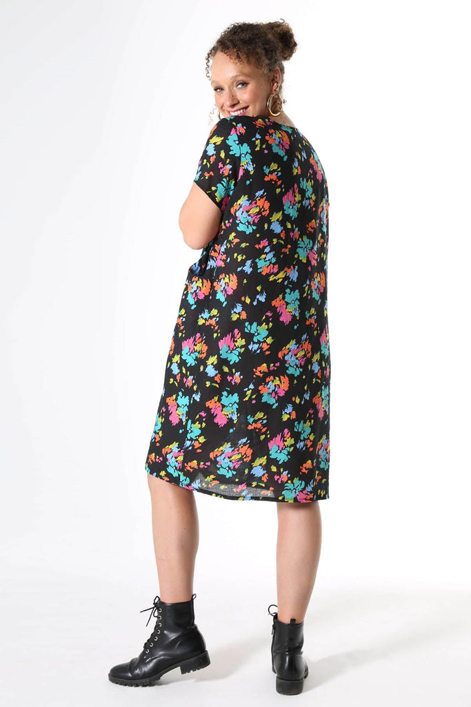 Olga de Polga knee length shift dress with short sleeves and pockets. Printed in Deep black with splashes of neon pink, orange, yellow and aqua. Soft, light-weight cotton/rayon fabric with a floaty drape.  