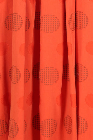 Olga de Polga Orange Universal top with a woven pattern of textured circles in the same orange. Fabric close up image