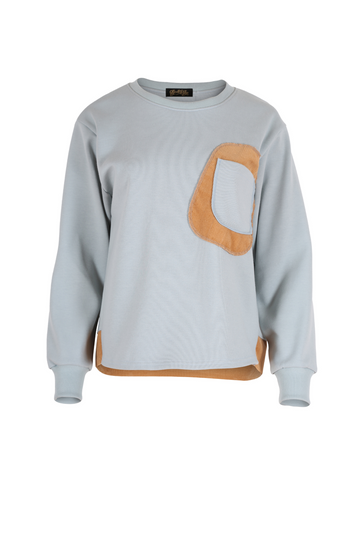 Olga de Polga new Transit sweatshirt in colour powder blue. Features a unique patchwork detail with pockets, low dropped shoulders and long sleeves. Front view